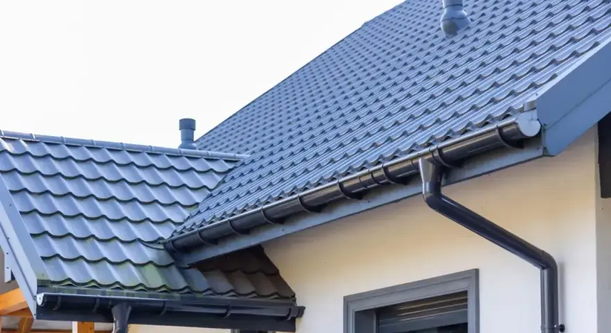 Szary dach z dachówki i rynny. Zastanawiasz się, ile farby na 100m2 dachu?