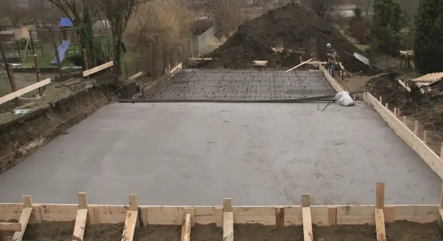 Wylewanie betonu na fundament. Widać zbrojenie i szalunki. Jaki beton na fundament wybrać?